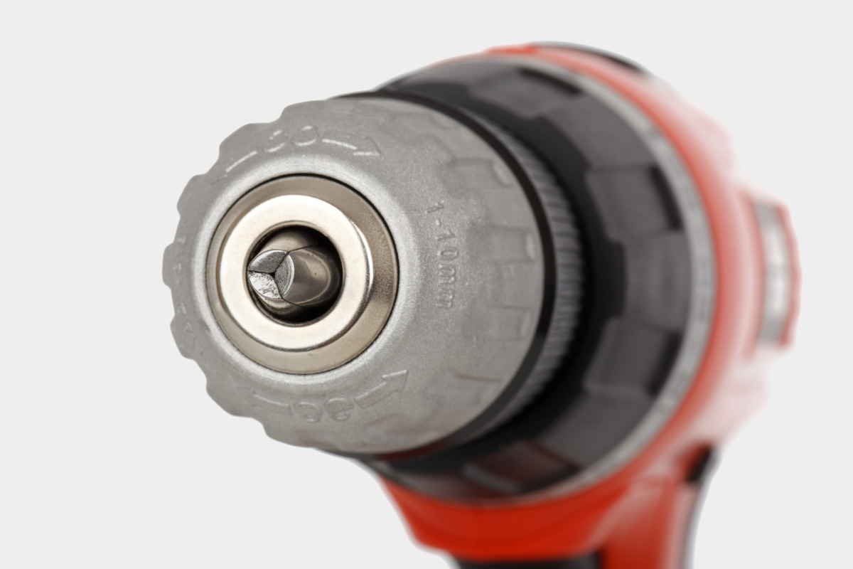 Close Up of Orange Power Drill Isolated on Gray Background