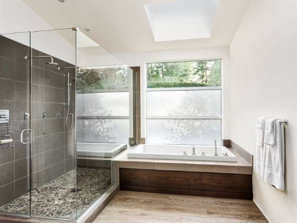 Master bathroom with a nice soaking tub and clear glass shower