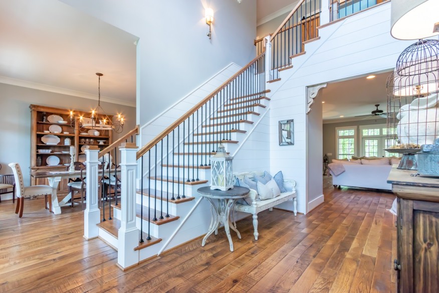 A white painted staircase leading up to the second floor of a home that has hardwood steps.