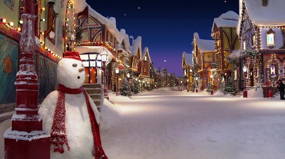 Snow-covered street with a snowman and Christmas decorations