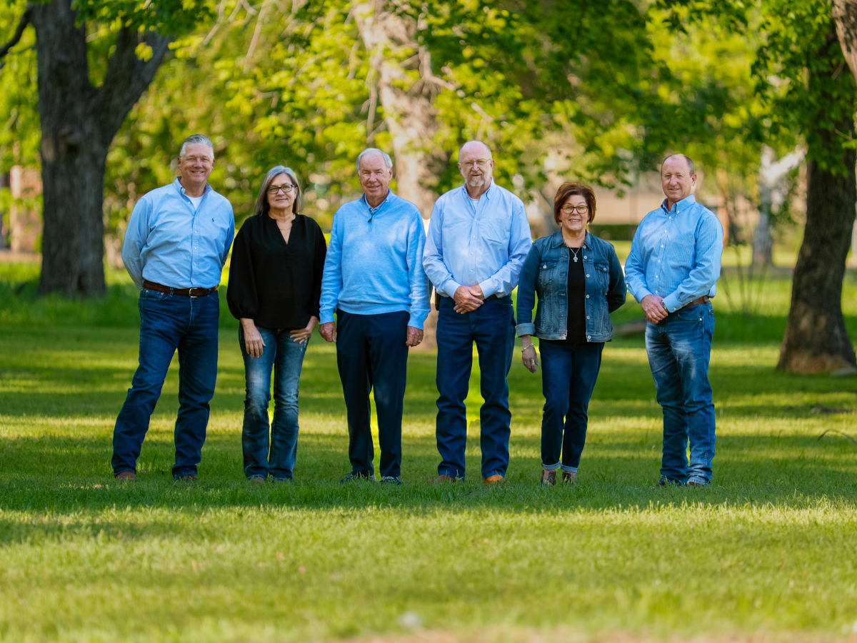 Owner Builder Network team standing on grass in front of old trees