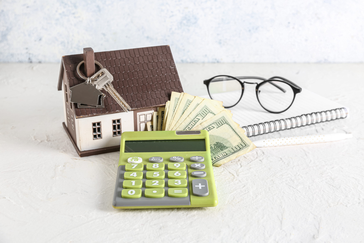 Model house next to keys and money.