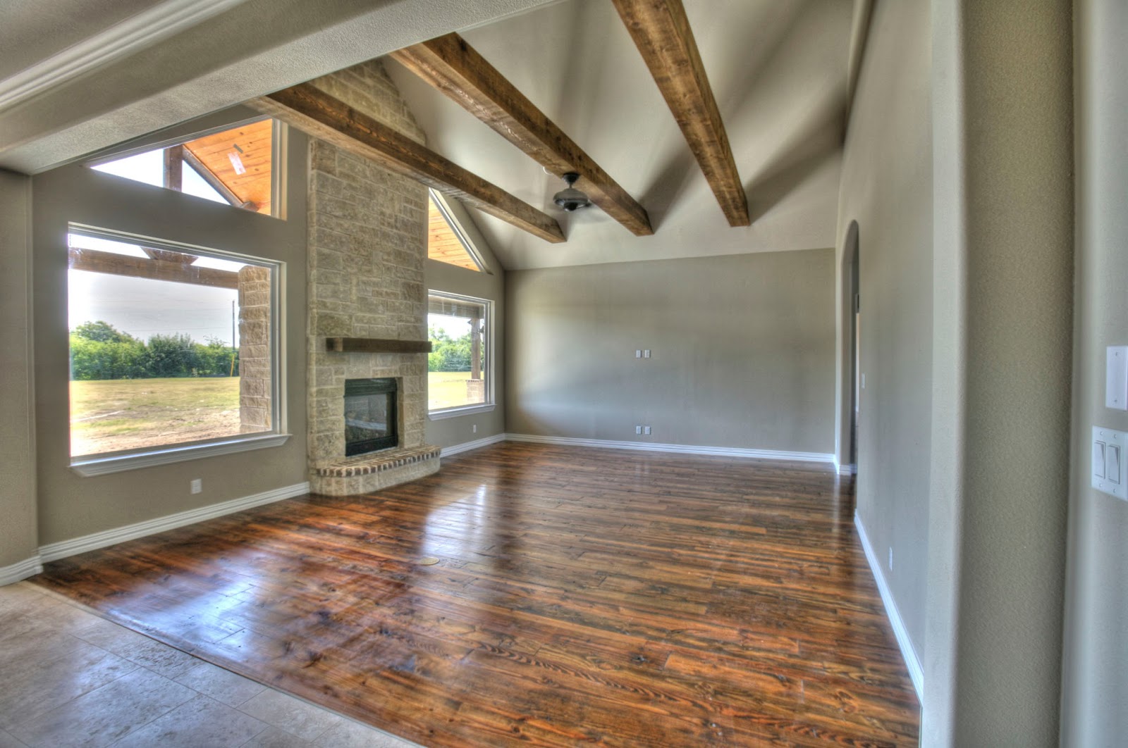 Living room with dark, hardwood floors and stone fireplace