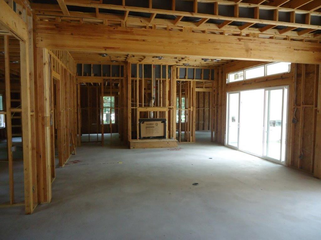 Interior framing with a vaulted ceiling and a wall of windows.