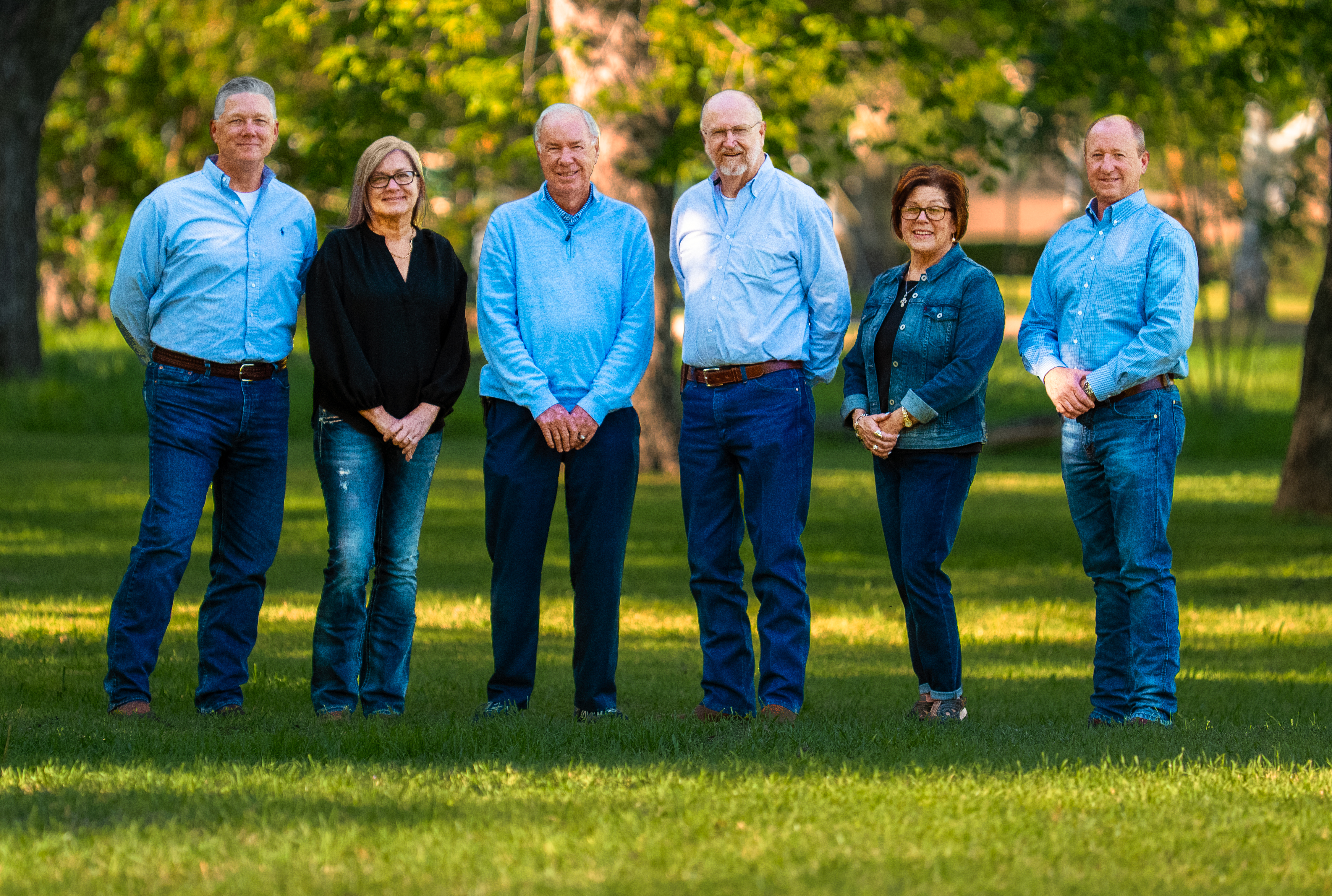 Owner Builder Network team standing on grass in front of old trees