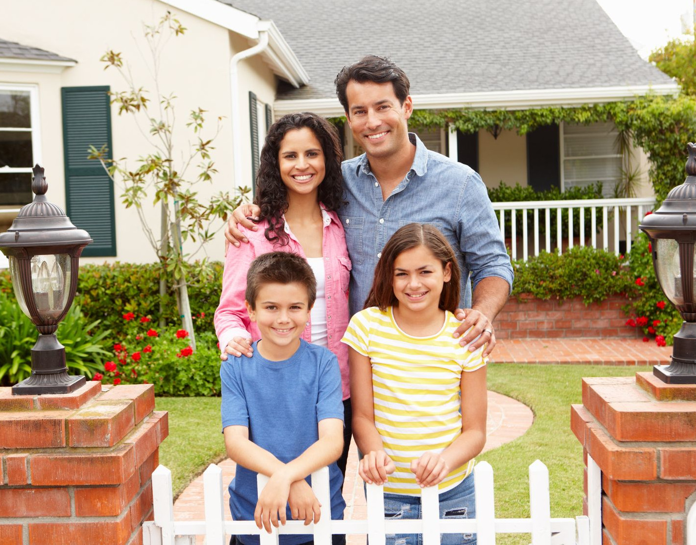 Happy family standing in front of their new home