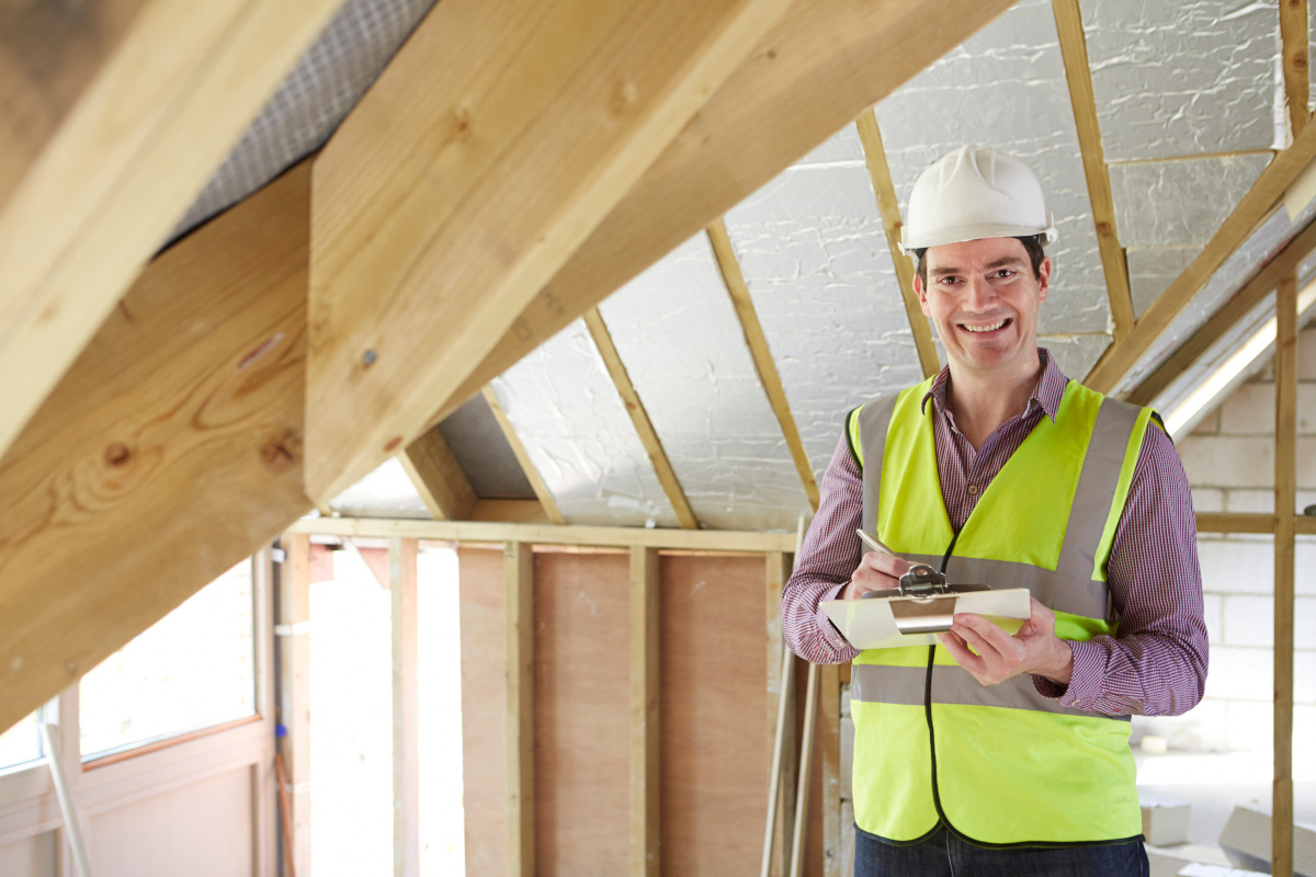 Builder in front of an unfinished house